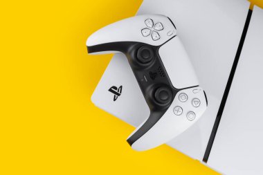 Dnipro Ukrayna - 29 Aralık 2024: Sarı bir masa üzerinde beyaz Sony Playstation 5 denetleyici ve PlayStation 5 konsolu.