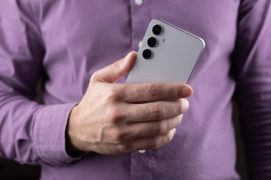 Elinde cep telefonu olan bir adama yaklaş..