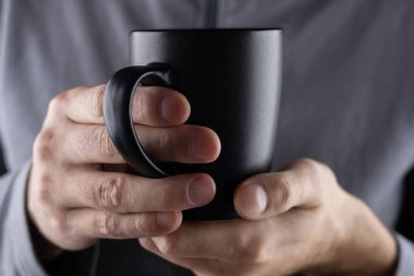 Erkekler siyah bardağı ellerinde tutarlar..