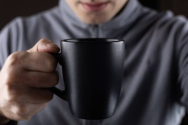 Erkekler siyah bardağı ellerinde tutarlar..