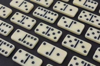 Koyu arkaplanda klasik domino taşları, düz yatış.