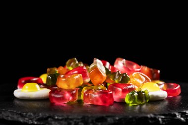 Renkli sakızlı şekerler. Taş tabakta jöleli şekerler.