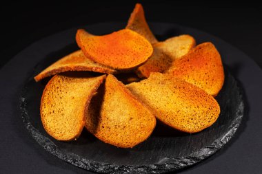 Koyu arkaplanda baharatlı çavdar ekmeği krakerleri, bira aperatifleri.,