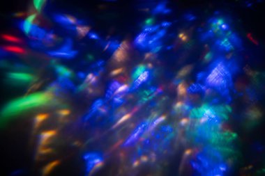 Siyah arkaplanda renkli ışık sızıntısı, uzun mercekte optik mercek parlaması olan soyut tasarım.