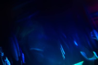 Bulanık neon ışık. Mercek alevi kaplaması. Bokeh floresan flaş parıltısı. Koyu siyah soyut arkaplanda odaklanmış mavi mor renk lekeleri.