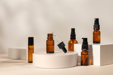 Geometrik kaide podyumunda kehribar kozmetik şişesi, bitkilerin doğal gölgelerini içeren ürün ambalajı, peptitli yaşlanma önleyici serum, kozmetik modelleme, biyofilik konsept..