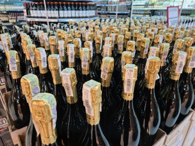 Dnipro, Ukrayna - 18 Şubat 2025: Süpermarkette şampanya şişeleri. Altın folyoda bir şişe şampanya. Süpermarkette bir sürü şampanya şişesi var..