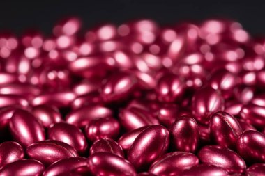 koyu arkaplanda vitaminlerin kırmızı yumuşak kapsülleri.