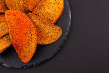 Koyu arkaplanda baharatlı çavdar ekmeği krakerleri, bira aperatifleri.,