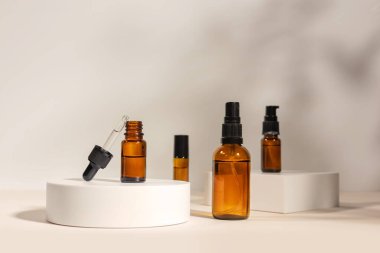 Geometrik kaide podyumunda kehribar kozmetik şişesi, bitkilerin doğal gölgelerini içeren ürün ambalajı, peptitli yaşlanma önleyici serum, kozmetik modelleme, biyofilik konsept..