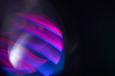 Siyah arkaplanda renkli ışık sızıntısı, uzun mercekte optik mercek parlaması olan soyut tasarım.