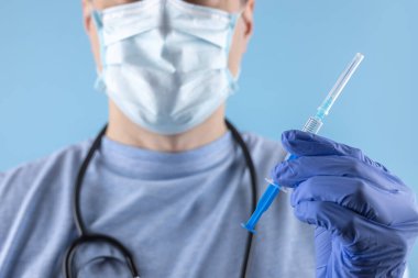 Eldivenli doktor şırıngayı ilaçlı tutuyor, yakın plan. Aşılama ve aşılama.