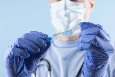 Eldivenli doktor şırıngayı ilaçlı tutuyor, yakın plan. Aşılama ve aşılama.