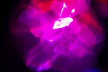 Renkli lens fişeği. Geleceğe yönelik bir geçmiş. Görüntü floresan UV 'nin öncülüğünde aydınlanma. Karanlık soyut örtüye odaklanmış neon mavisi pembe ışık.