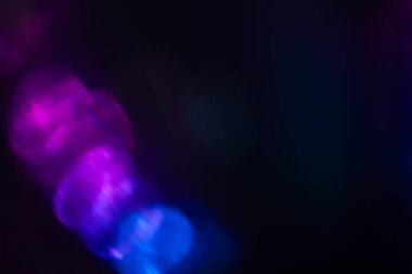 Siyah arkaplanda renkli ışık sızıntısı, uzun mercekte optik mercek parlaması olan soyut tasarım.