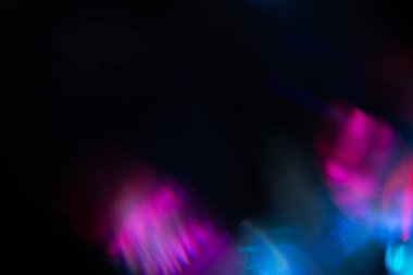 Bulanık neon ışık. Mercek alevi kaplaması. Bokeh floresan flaş parıltısı. Koyu siyah soyut arkaplanda odaklanmış mavi mor renk lekeleri.