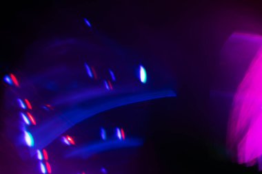 Siyah arkaplanda renkli ışık sızıntısı, uzun mercekte optik mercek parlaması olan soyut tasarım.