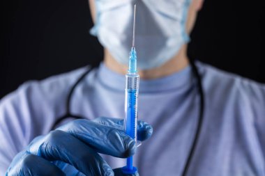 Doktor ya da bilim adamı, grip, kızamık, koronavirüs aşısı aşısı, salgın aşısı, ilaç ve uyuşturucu içeren mavi nitril eldivenler verdi.