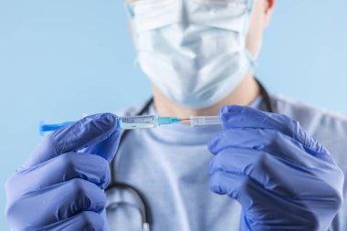 Doktor ya da bilim adamı, grip, kızamık, koronavirüs aşısı aşısı, salgın aşısı, ilaç ve uyuşturucu içeren mavi nitril eldivenler verdi.