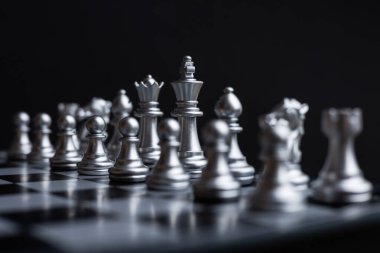 Satranç tahtasına yerleştirilmiş beyaz satranç taşları görsel olarak çekici ve stratejik bir kompozisyon oluşturuyor..