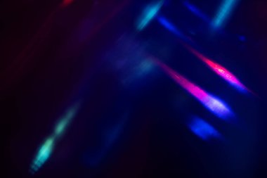 Siyah arkaplanda renkli ışık sızıntısı, uzun mercekte optik mercek parlaması olan soyut tasarım.