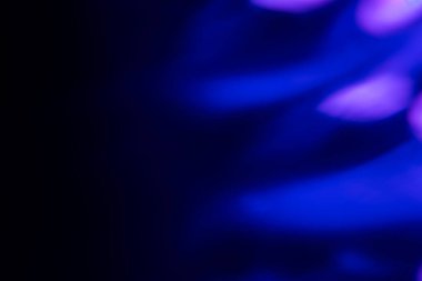 Bulanık neon ışık. Mercek alevi kaplaması. Bokeh floresan flaş parıltısı. Koyu siyah soyut arkaplanda odaklanmış mavi mor renk lekeleri.