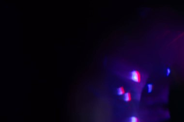Bulanık neon ışık. Mercek alevi kaplaması. Bokeh floresan flaş parıltısı. Koyu siyah soyut arkaplanda odaklanmış mavi mor renk lekeleri.