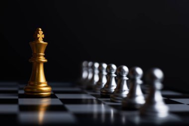 Savaşta satranç oynayan Kral, siyah arka planlı satranç tahtasının üzerinde duruyor. Piyasa hedef stratejisi için iş lideri konsepti. Zeka yarışması ve iş yarışması başarısı oyunu.