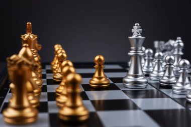 Kral gümüş satranç, altın satranç takımının karşısında duruyor. Satranç tahtası iş fikirleri ve rekabet ve strateji planı kavramı başarı anlamına gelir