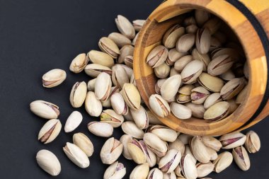 Ahşap kasede fındıklı, siyah arka planda..