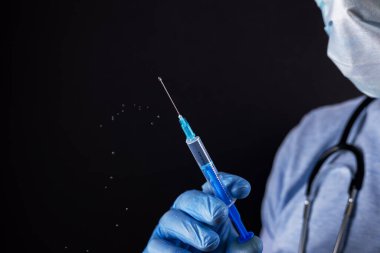 Eldivenli doktor şırıngayı ilaçlı tutuyor, yakın plan. Aşılama ve aşılama.