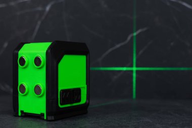 Bloklardan bir duvar inşa ederken lazer seviyesi. İnşaat alanlarındaki hatları ve seviyeleri belirlemek için lazer seviyesi tamamlanmamış beton bloklardan yapılmış bir duvarın üzerinde duruyor..