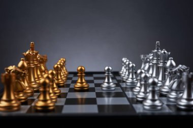 Altın piyon satranç yüzü kapalı gümüş piyon satranç arka planı.