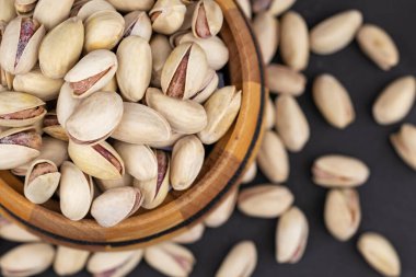 Gri bir arka planda kavrulmuş ve tuzlu şam fıstığı..