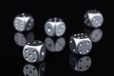 Yukarıdan siyah arkaplanda beş gümüş zar görünümü.