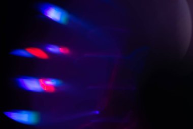 Bulanık neon ışık. Mercek alevi kaplaması. Bokeh floresan flaş parıltısı. Koyu siyah soyut arkaplanda odaklanmış mavi mor renk lekeleri.