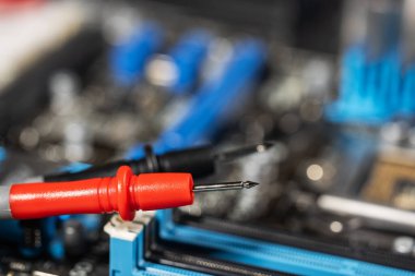 kırmızı ve siyah çoklu metre sonda elektrik bileşenlerini kontrol ediyor. Teknik laboratuvar ortamında tanısal test