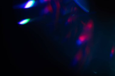 Siyah arkaplanda renkli ışık sızıntısı, uzun mercekte optik mercek parlaması olan soyut tasarım.