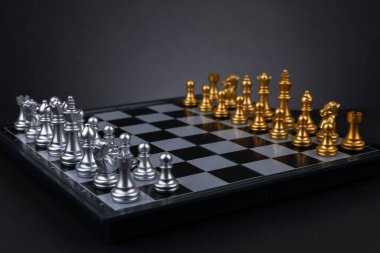 Satranç tahtasıyla satranç taşları karanlık arka planda oyun için hazır..