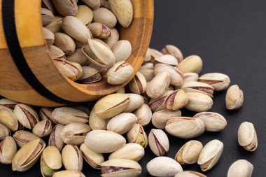 Gri bir arka planda kavrulmuş ve tuzlu şam fıstığı..