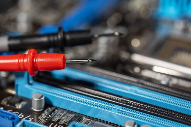 kırmızı ve siyah çoklu metre sonda elektrik bileşenlerini kontrol ediyor. Teknik laboratuvar ortamında tanısal test