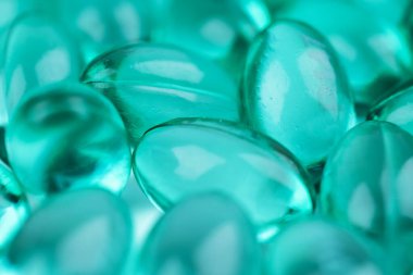 Kabukta sıvı vitaminli mavi kapsüller. Eklem dişleri ve kemikler için beslenme takviyesi içeren mavi kapsüller..