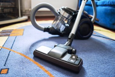 Odada halı fırçası olan modern elektrikli süpürge..