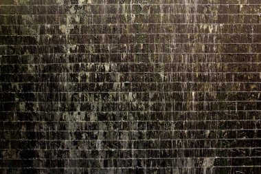 Her zaman aşağı akan bir şelalenin olduğu bir duvar resmi. Yeşil yosunların büyümesine neden oluyor..