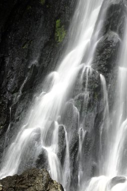 Su kayalıklardan aşağı akıyor. Uçuruma çarpar ve sis yaratır.