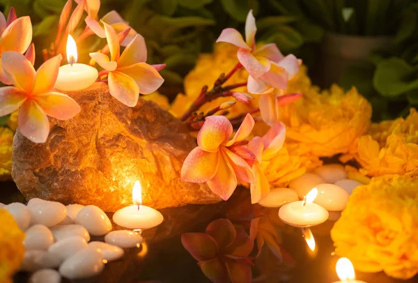 A meditative and relaxing atmosphere with candlelight, flowers and moisture.