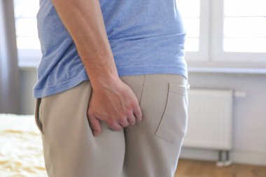 Onun alt karın ağrısı ve hemoroid, sağlık kavramı çünkü tutan adam el. Adam hemoroid ve kabızlık.