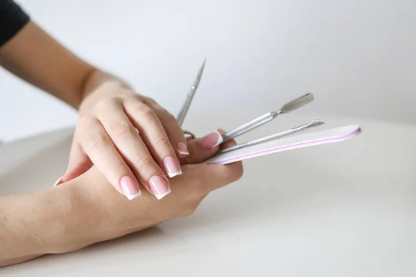 Close Van Vrouw Handen Houden Manicure Tools Een Witte Achtergrond — Stockfoto