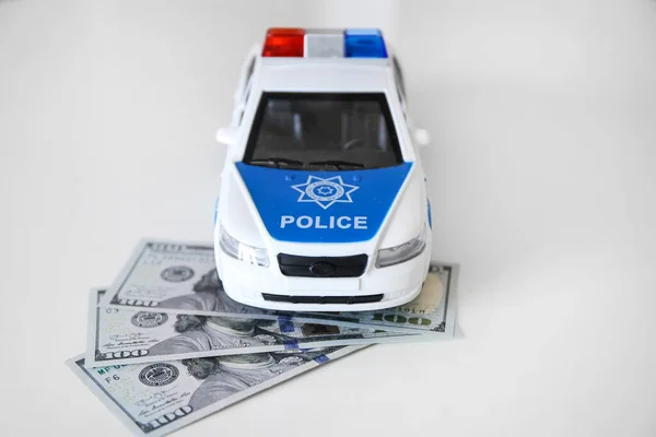 Police car and a wad of money. Call the police. Fine. Bribes. Police work. The salary