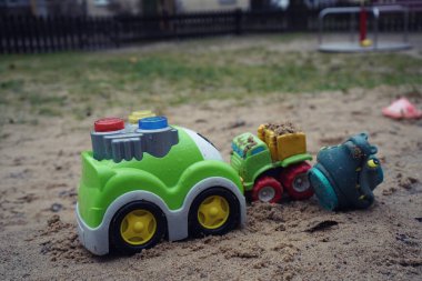 Çocuk kışın ya da sonbaharda oyun alanında, açık havada, kışın kum havuzunda oynar.